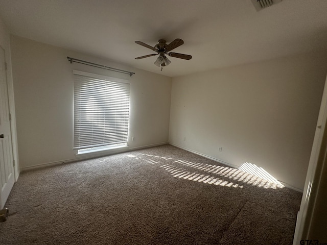 carpeted spare room featuring ceiling fan