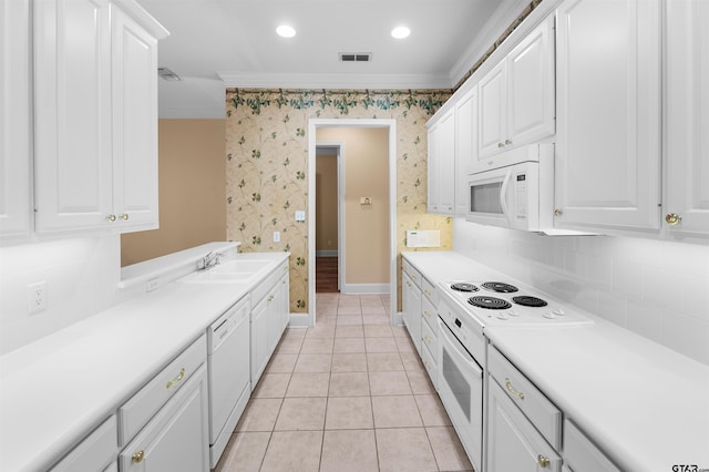 2322 Dietz Ln, Tyler, TX 75701 - kitchen featuring wallpapered walls, light countertops, white appliances, crown molding, and white cabinetry