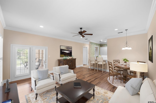 2322 Dietz Ln, Tyler, TX 75701 - living area featuring baseboards, ornamental molding, ceiling fan with notable chandelier, and light wood-style flooring