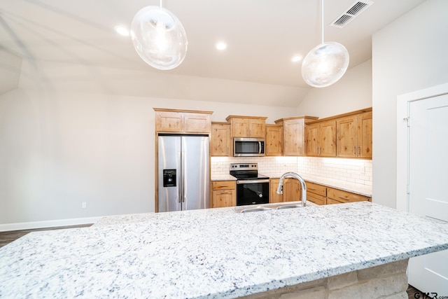 kitchen featuring sink, hanging light fixtures, lofted ceiling, and appliances with stainless steel finishes