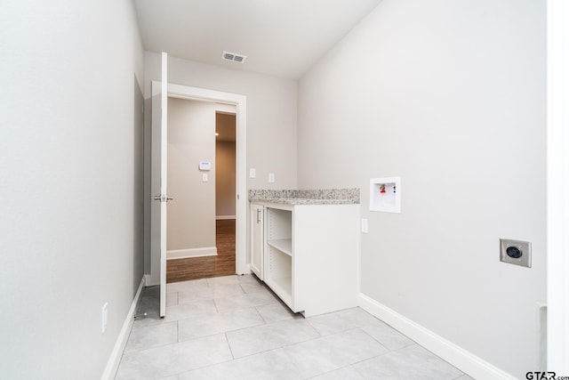 washroom featuring hookup for an electric dryer, light tile patterned floors, and hookup for a washing machine