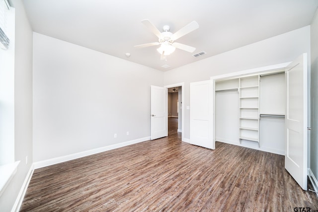 unfurnished bedroom with a closet, dark hardwood / wood-style floors, and ceiling fan