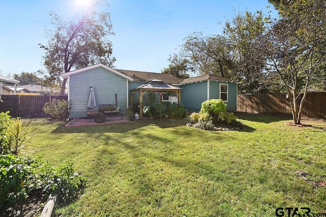 back of property featuring a gazebo and a yard