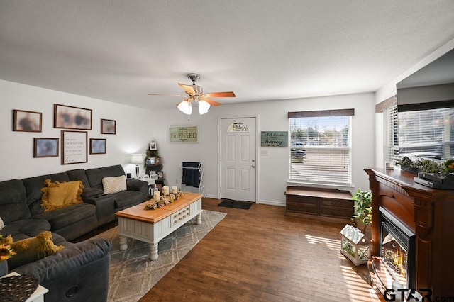 living room featuring ceiling fan and dark wood-type flooring