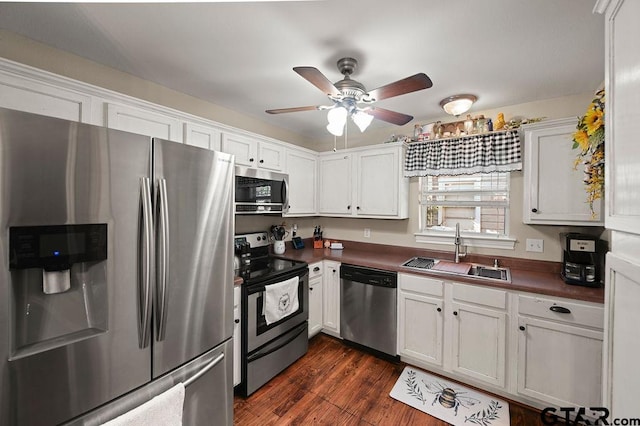 kitchen with appliances with stainless steel finishes, dark hardwood / wood-style flooring, ceiling fan, sink, and white cabinetry