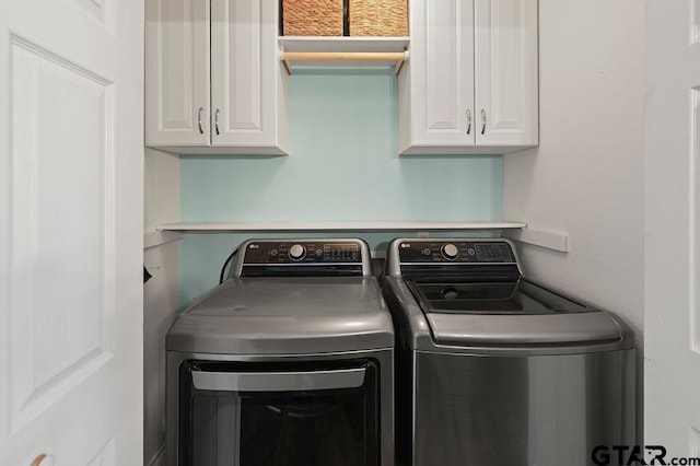 laundry room featuring separate washer and dryer and cabinets