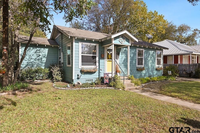 view of front facade featuring crawl space, fence, and a front lawn