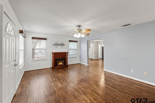 living room with dark hardwood / wood-style floors, plenty of natural light, and ceiling fan