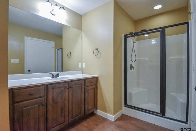 bathroom featuring hardwood / wood-style floors, vanity, and an enclosed shower