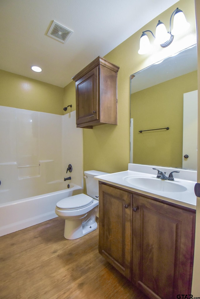 full bathroom with vanity, hardwood / wood-style flooring, shower / washtub combination, and toilet