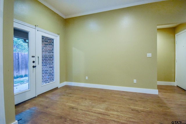 spare room featuring ornamental molding, french doors, and light hardwood / wood-style flooring