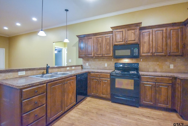 kitchen featuring light hardwood / wood-style floors, sink, black appliances, and kitchen peninsula