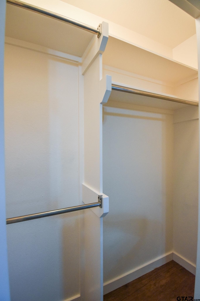 spacious closet with dark wood-type flooring