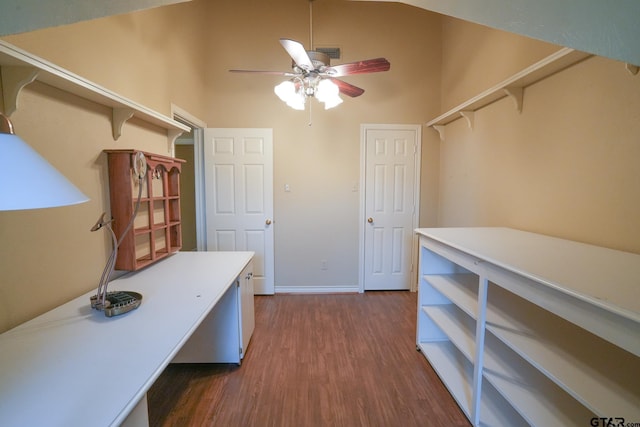 office space with ceiling fan, dark hardwood / wood-style floors, and a towering ceiling