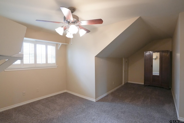 additional living space with ceiling fan, lofted ceiling, and dark carpet