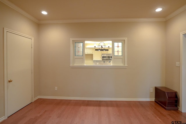 spare room with ornamental molding and light hardwood / wood-style floors