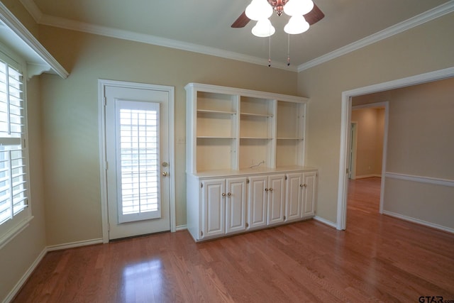 interior space with ornamental molding, ceiling fan, and light hardwood / wood-style floors