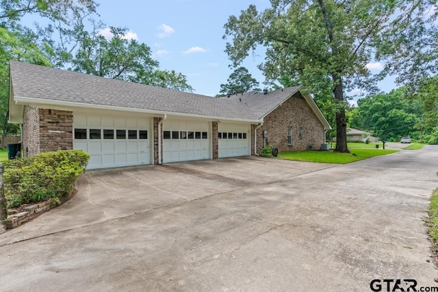 1805 Greenway St, Gilmer, TX 75644 - view of front of house featuring brick siding, concrete driveway, a shingled roof, an attached garage, and a front yard