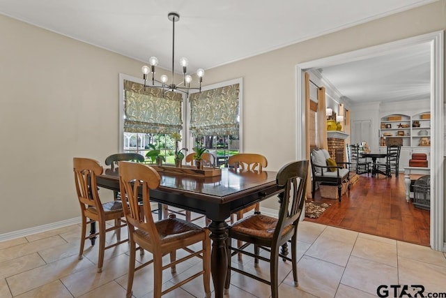 1805 Greenway St, Gilmer, TX 75644 - dining room with a chandelier, light tile patterned floors, ornamental molding, a fireplace, and baseboards