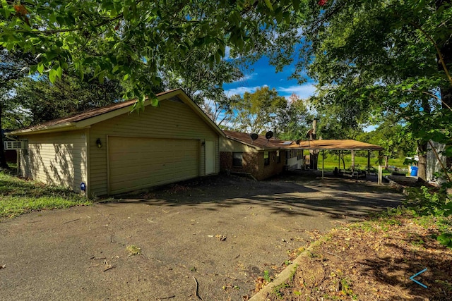 view of home's exterior with a garage and a carport