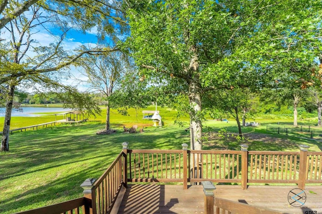 wooden terrace featuring a water view and a yard