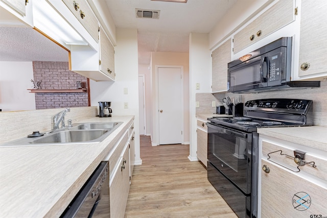 kitchen featuring black appliances, tasteful backsplash, light wood-type flooring, and sink