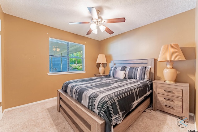 bedroom featuring a textured ceiling, light carpet, and ceiling fan