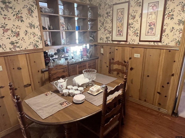 dining room featuring hardwood / wood-style flooring and wood walls