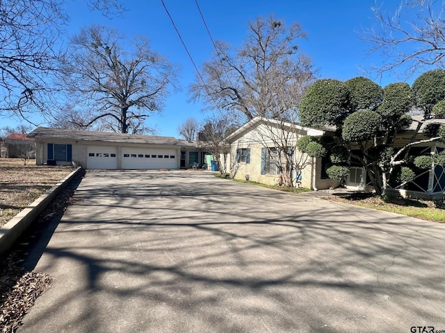 view of front facade featuring driveway, an attached garage, and brick siding