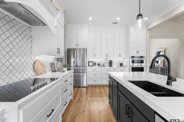 12293 Harlon St, Flint, TX 75762 - kitchen featuring stainless steel appliances, white cabinets, dark cabinetry, ventilation hood, and decorative light fixtures
