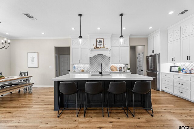 12293 Harlon St, Flint, TX 75762 - kitchen with high end fridge, light countertops, ornamental molding, white cabinets, and a kitchen breakfast bar