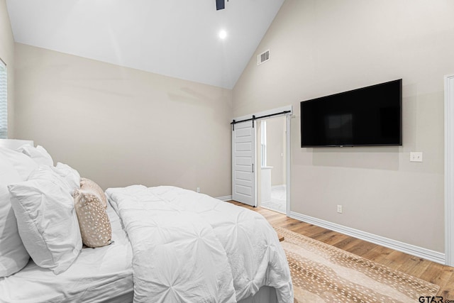 12293 Harlon St, Flint, TX 75762 - bedroom featuring a barn door, light wood-type flooring, high vaulted ceiling, and a ceiling fan