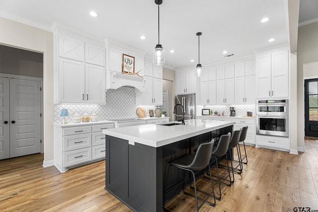 12293 Harlon St, Flint, TX 75762 - kitchen with appliances with stainless steel finishes, light wood-type flooring, light countertops, ornamental molding, and white cabinetry