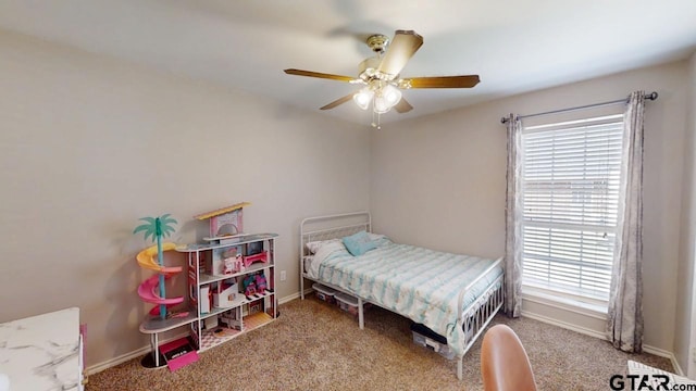 carpeted bedroom featuring multiple windows, a ceiling fan, and baseboards