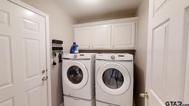 laundry room with cabinet space and washer and clothes dryer