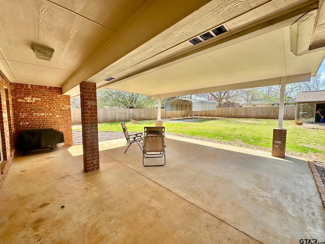 view of patio with a storage unit, a fenced backyard, and an outdoor structure