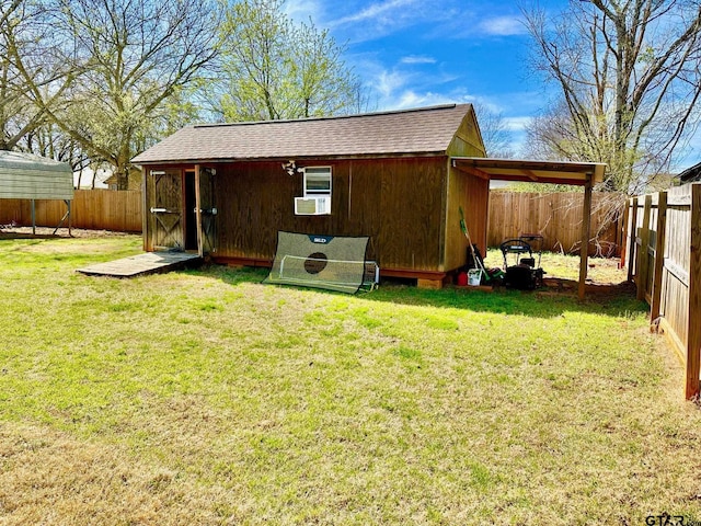 exterior space with an outbuilding, a fenced backyard, and a carport