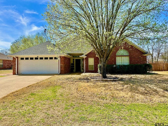 ranch-style house featuring brick siding, an attached garage, fence, roof with shingles, and driveway