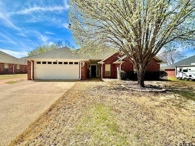 single story home featuring driveway, brick siding, and an attached garage