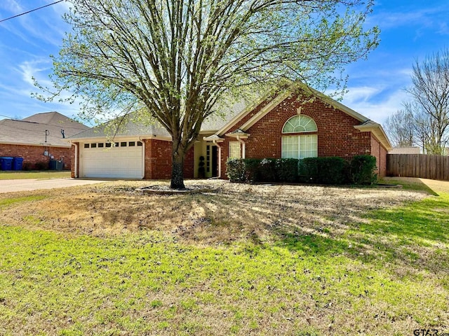 ranch-style home with a front yard, fence, concrete driveway, a garage, and brick siding