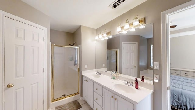 ensuite bathroom featuring a sink, visible vents, a stall shower, and double vanity