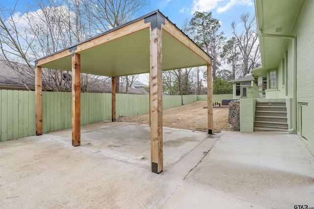 view of patio / terrace with a carport and a fenced backyard