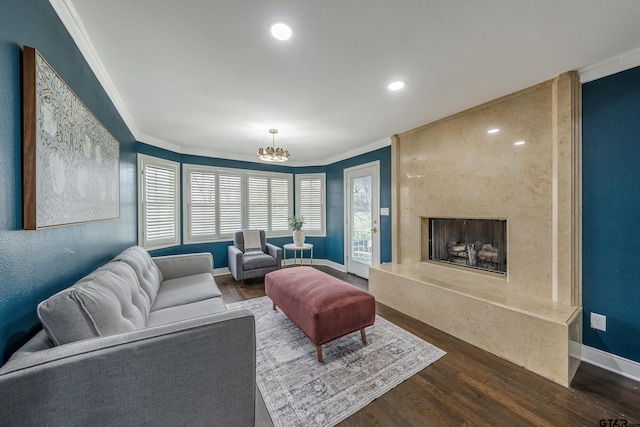 living area with ornamental molding, a high end fireplace, and wood finished floors