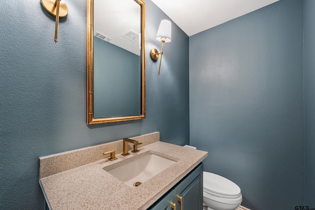 bathroom featuring toilet, visible vents, and vanity