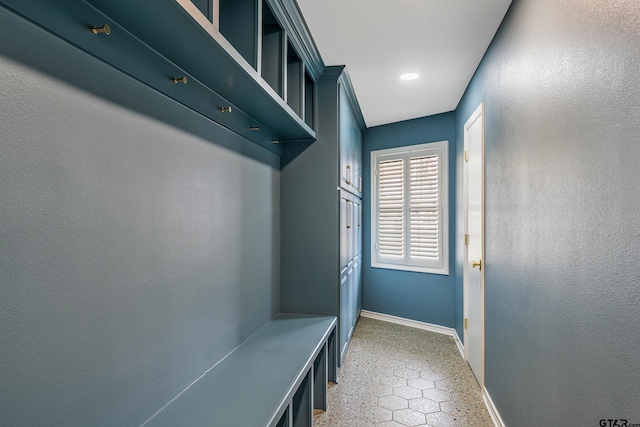 mudroom featuring light floors and baseboards