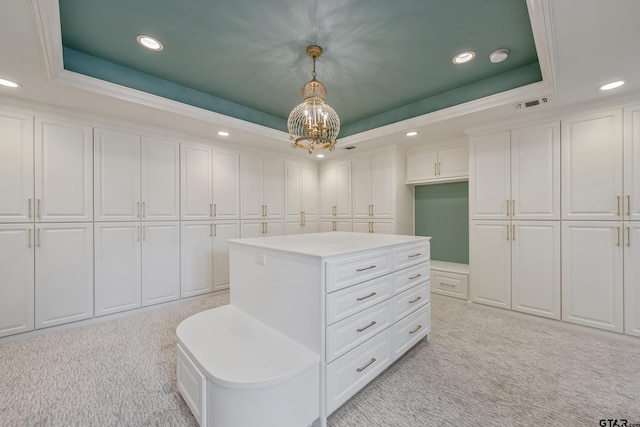 spacious closet featuring a notable chandelier, a tray ceiling, visible vents, and light colored carpet