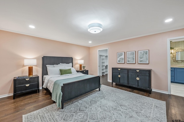 bedroom with a walk in closet, crown molding, and wood finished floors