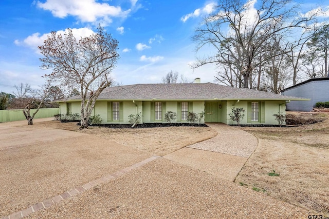 ranch-style home with a chimney, fence, and stucco siding