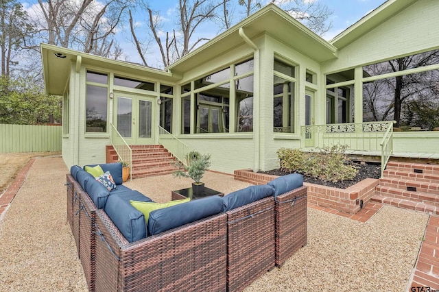 exterior space with entry steps, fence, an outdoor living space, and french doors