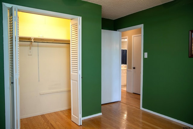3505 Cloverdale Dr, Tyler, TX 75701 - unfurnished bedroom with wood finished floors, a closet, baseboards, and a textured ceiling